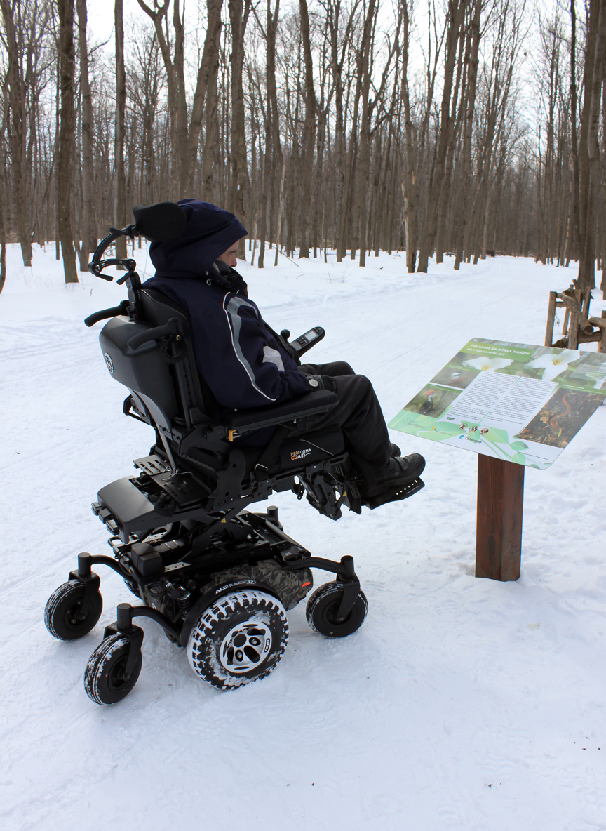 Amylior Alltrack power wheelchair on a snowy forest trail.